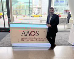 A picture of CEO Bill Laursen standing next to an AAOS sign