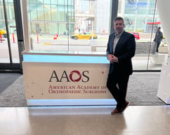 A picture of CEO Bill Laursen standing next to an AAOS sign