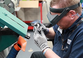 An employee looks closely at an orthopedic implant