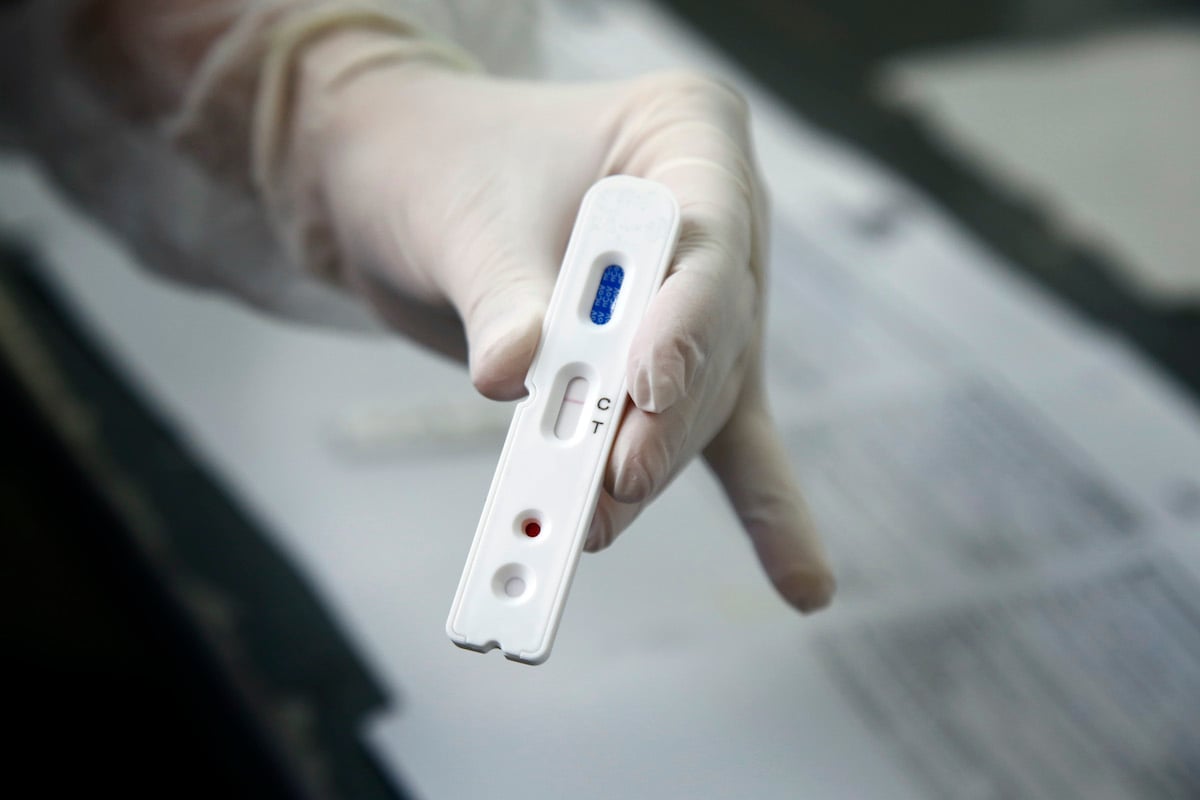 Close up of a hand holding a medical testing kit