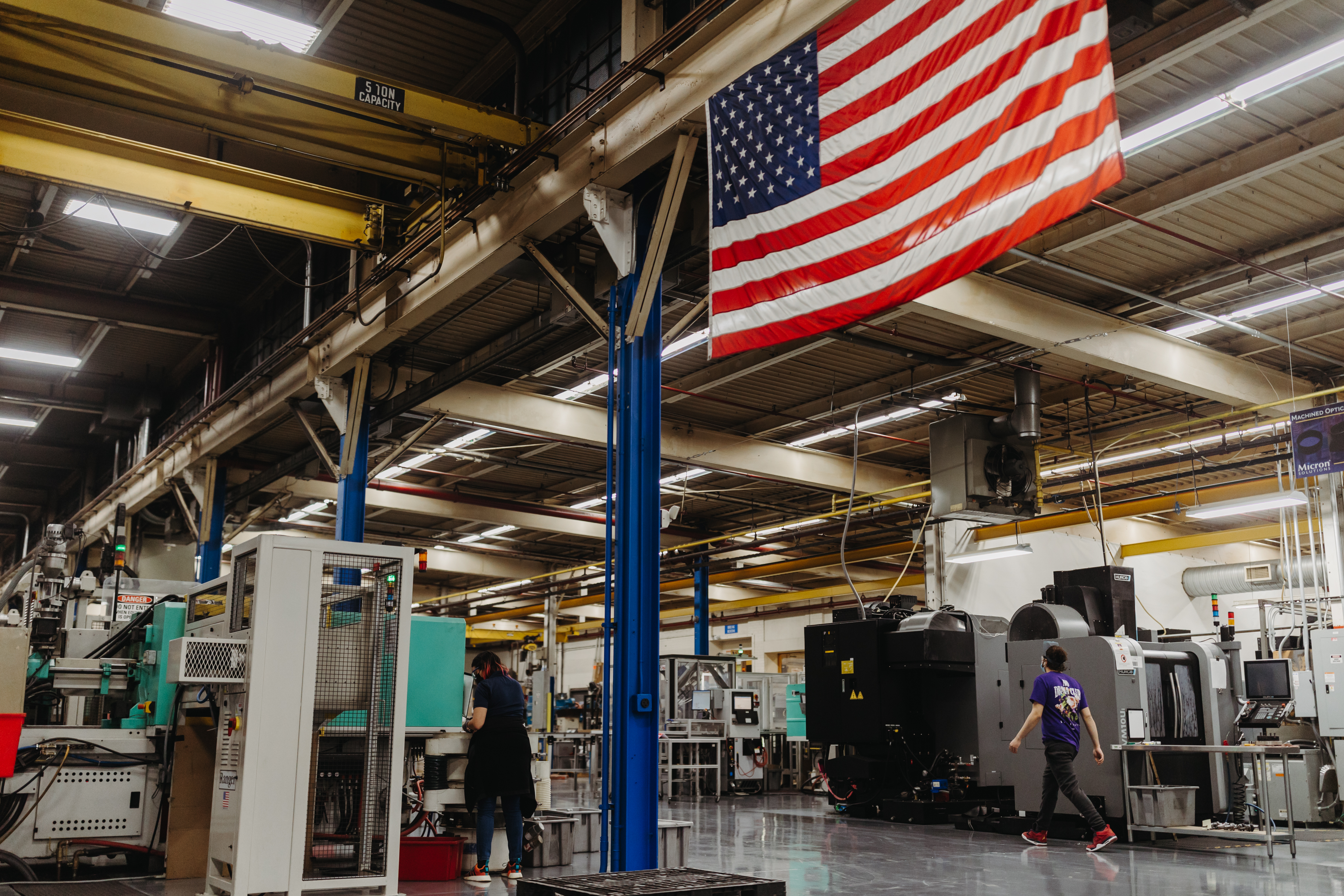 An American flag hangs over the manufacturing floor