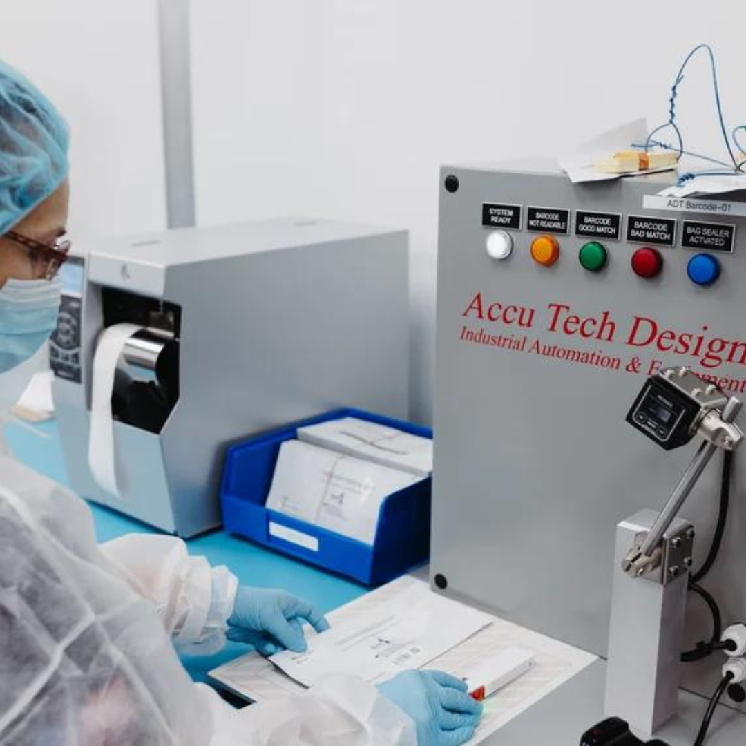 An employee in a cleanroom comparing a device to a diagram on paper