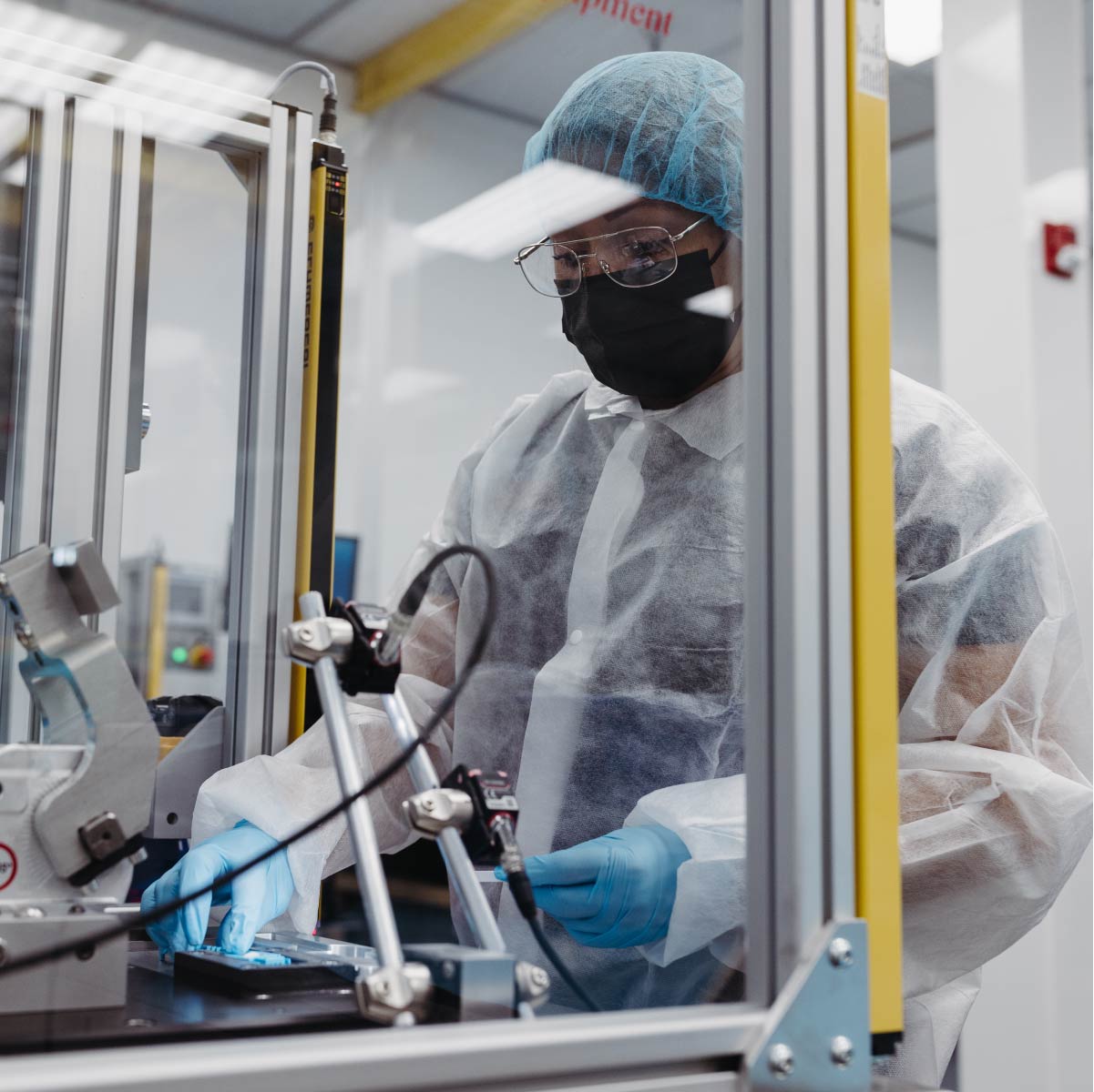 A woman works carefully on a single COVID-19 test kit