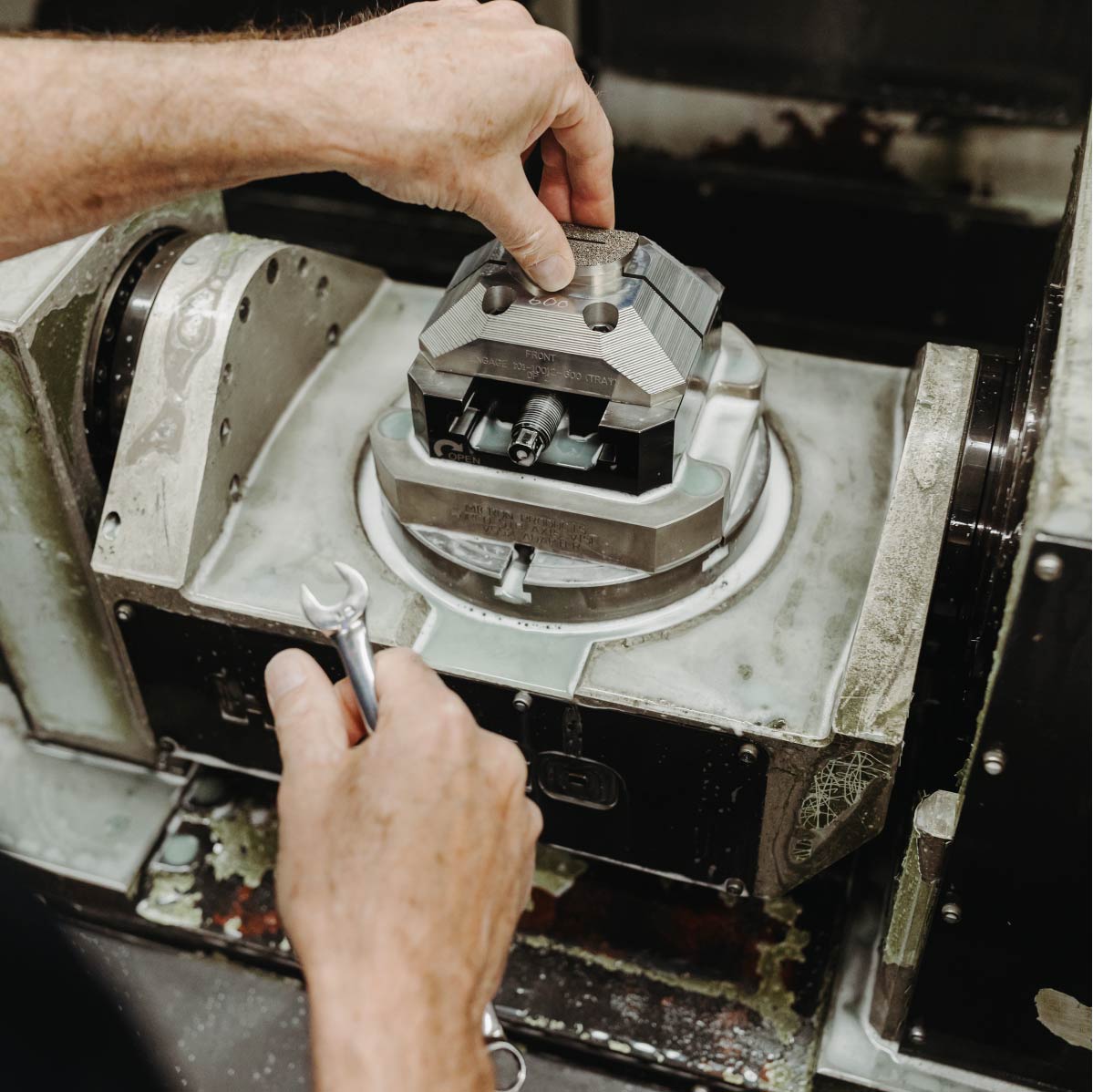 Close up of an employee holding a wrench and working on a product