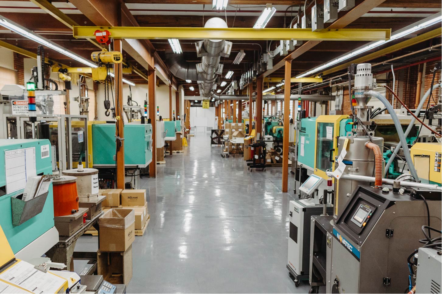 Manufacturing floor featuring two rows of Arburg injection molding machines